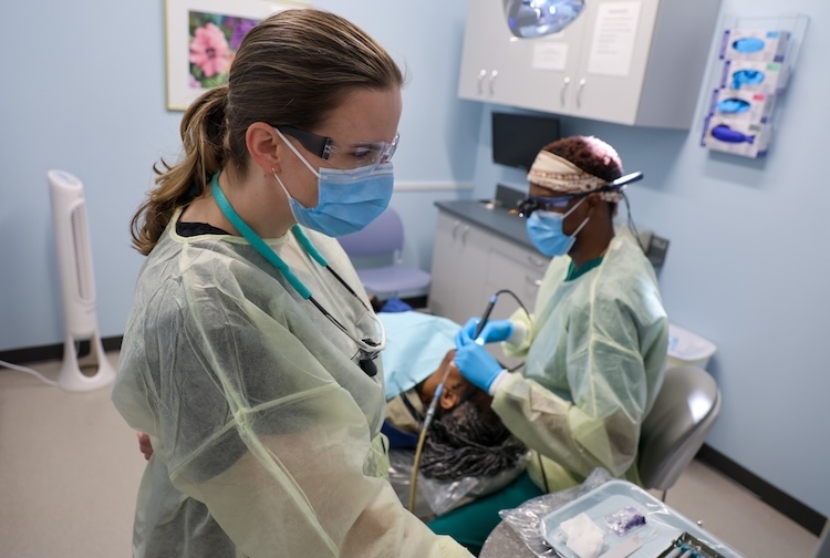 Dental hygienist works with student to evaluate a patient
