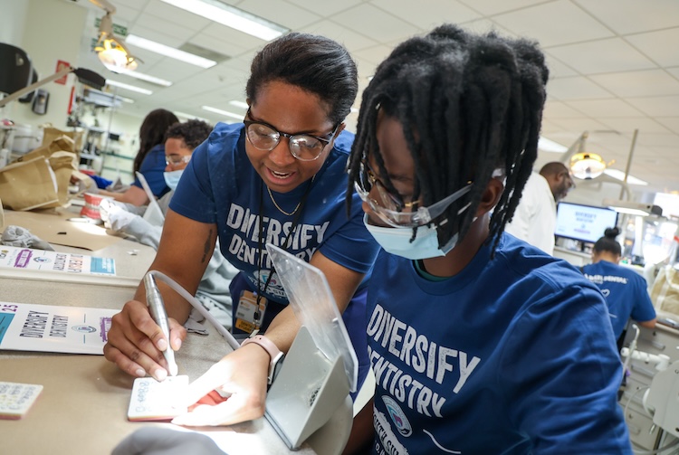 Dental Student helping high schooler with an activity